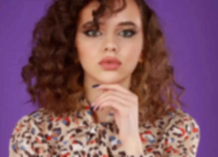 Curly haired woman portrait purple background